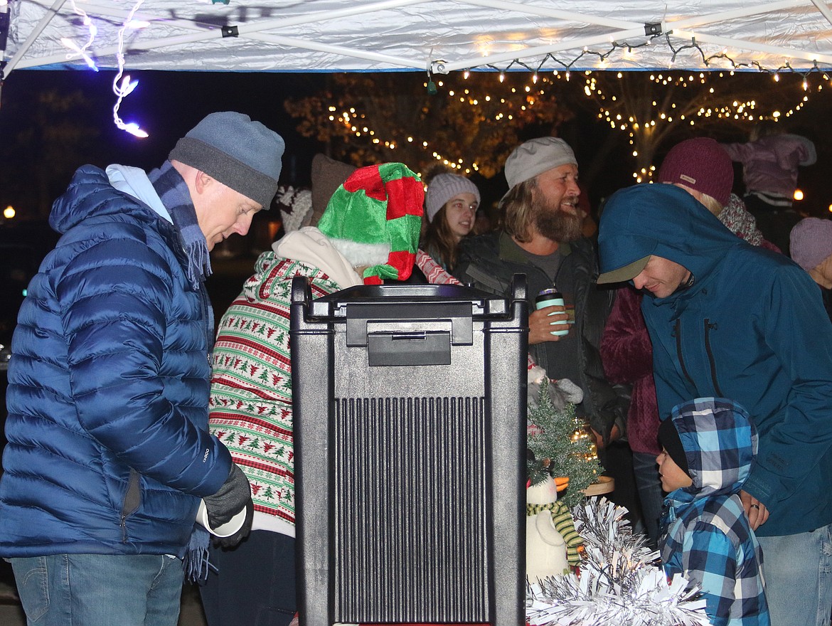 Area residents line up for a cup of hot chocolate during Friday's annual tree lighting ceremony.