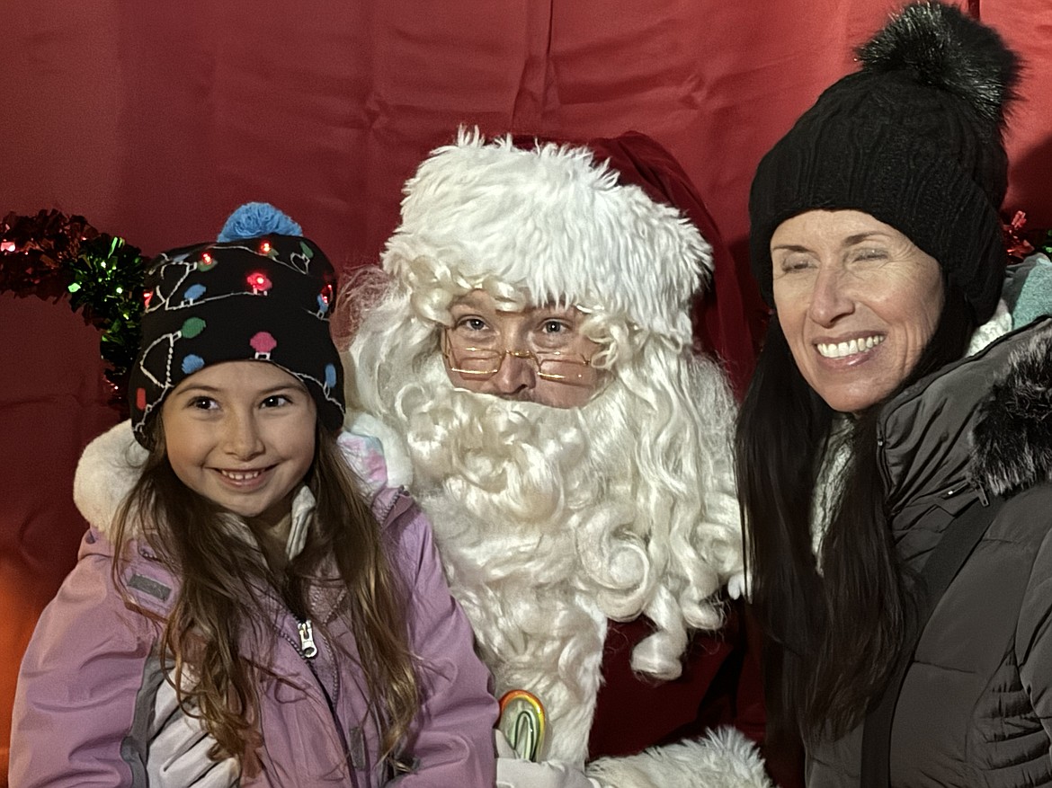 Santa Claus poses for a photo with a pair of fans as the Jolly Old Elf came to Sandpoint on Friday for the town's annual tree lighting ceremony.