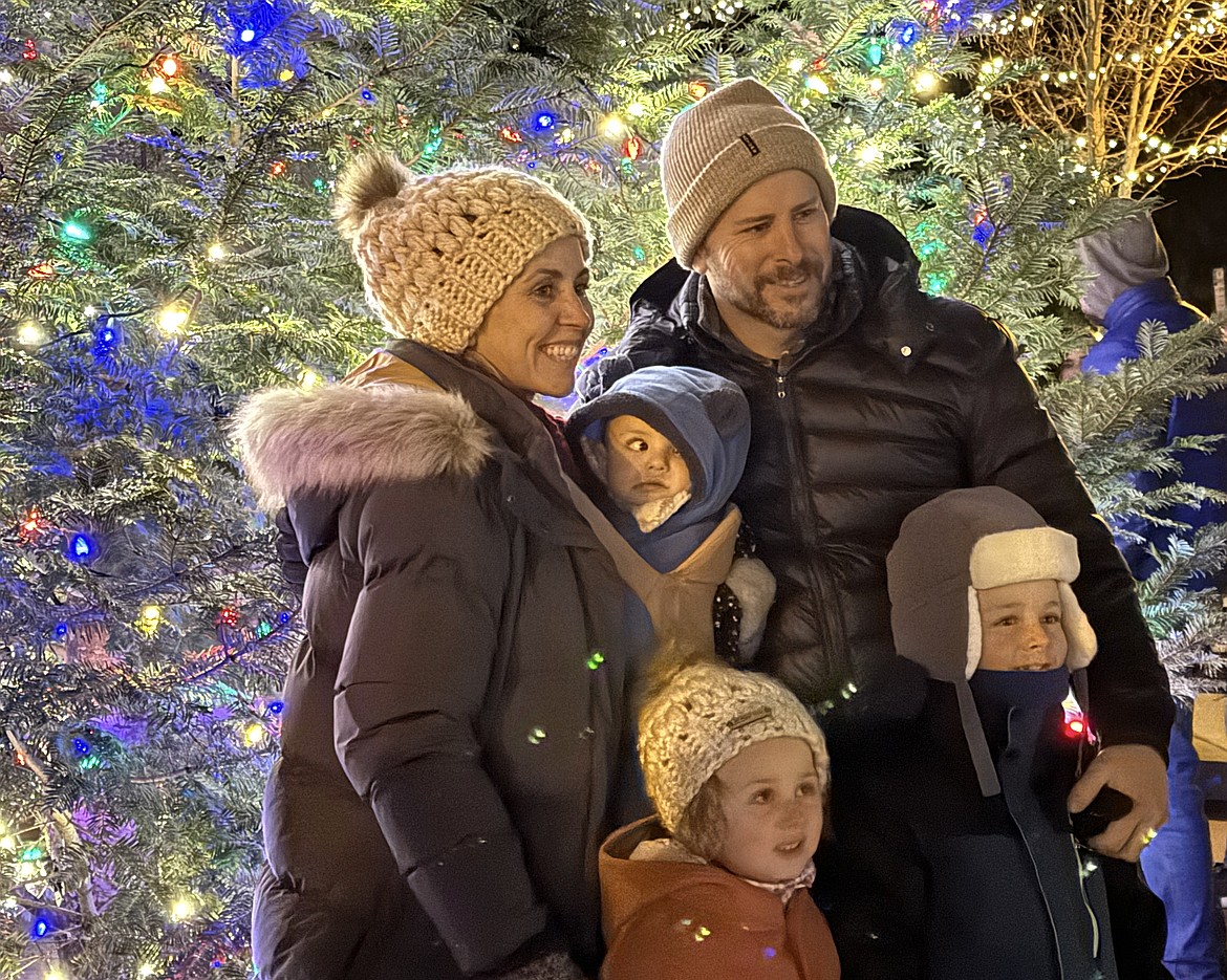 A family poses for a photo after the town Christmas tree was lit for the first time on Friday.