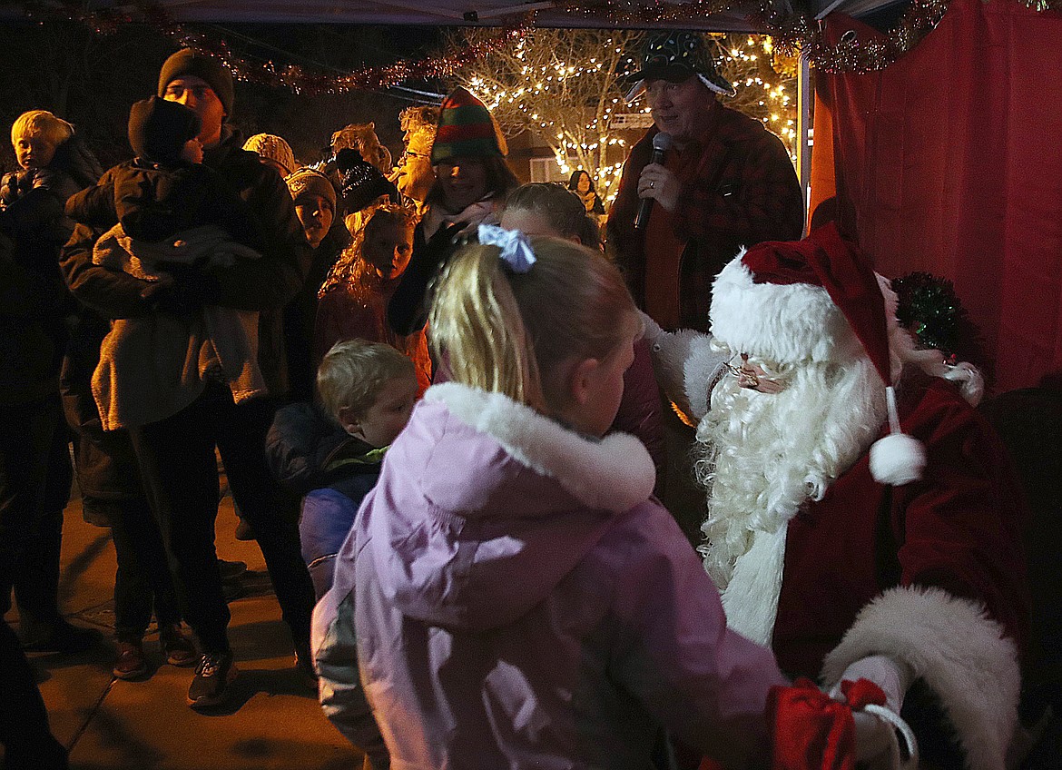 Santa Claus listens as a young fan shares what they would like for Christmas.