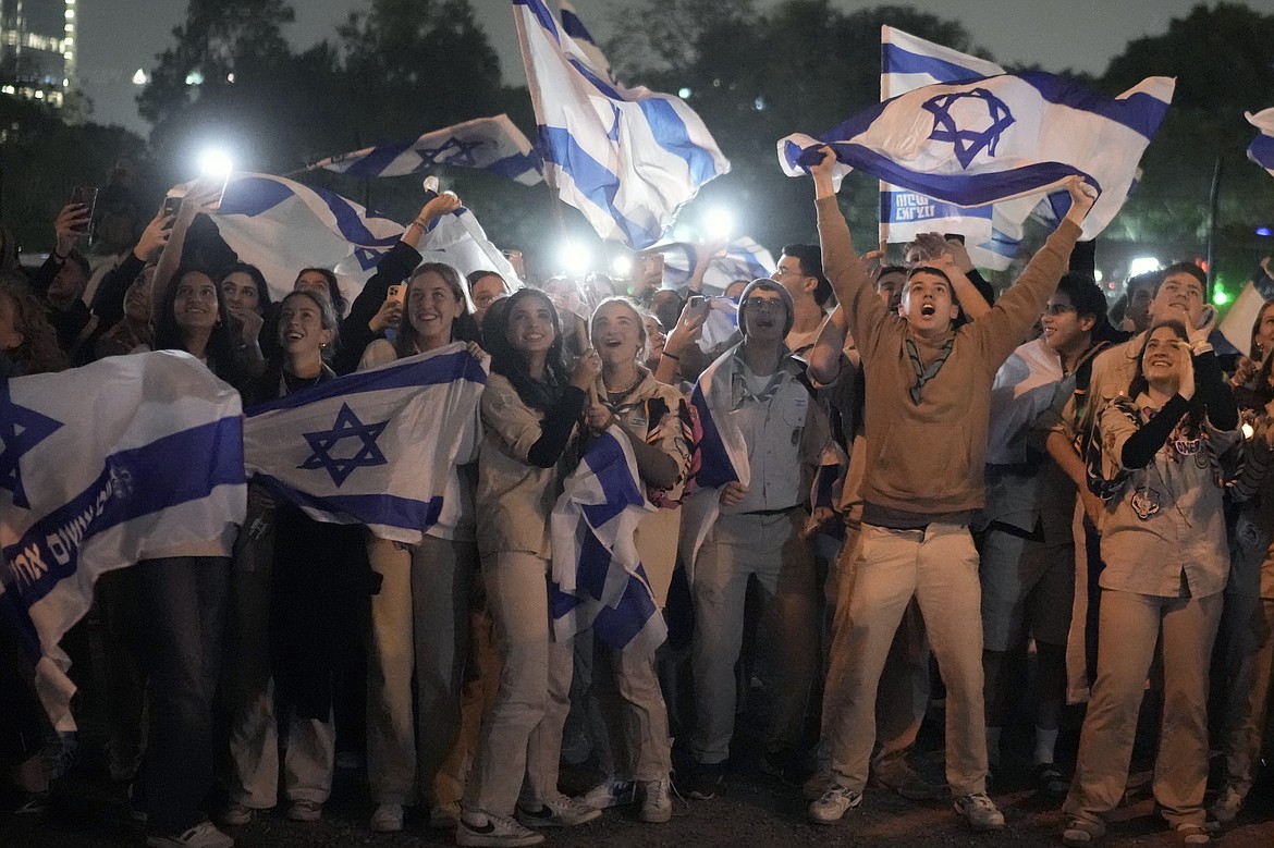 A group of Israelis celebrate as a helicopter carrying hostages released from the Gaza Strip lands at the helipad of the Schneider Children's Medical Center in Petah Tikva, Israel, Sunday Nov. 26, 2023. The cease-fire between Israel and Hamas was back on track Sunday as the militants freed 17 more hostages, including 14 Israelis and the first American, in exchange for 39 Palestinian prisoners in a third set of releases under a four-day truce. (AP Photo/Leo Correa)