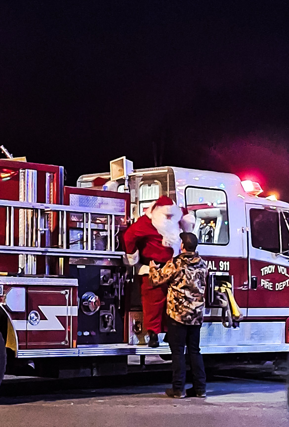 Santa Claus gets a hand getting off the Troy Volunteer Fire Department truck in Troy on Saturday, Nov. 25. (Hannah Chumley/The Western News)