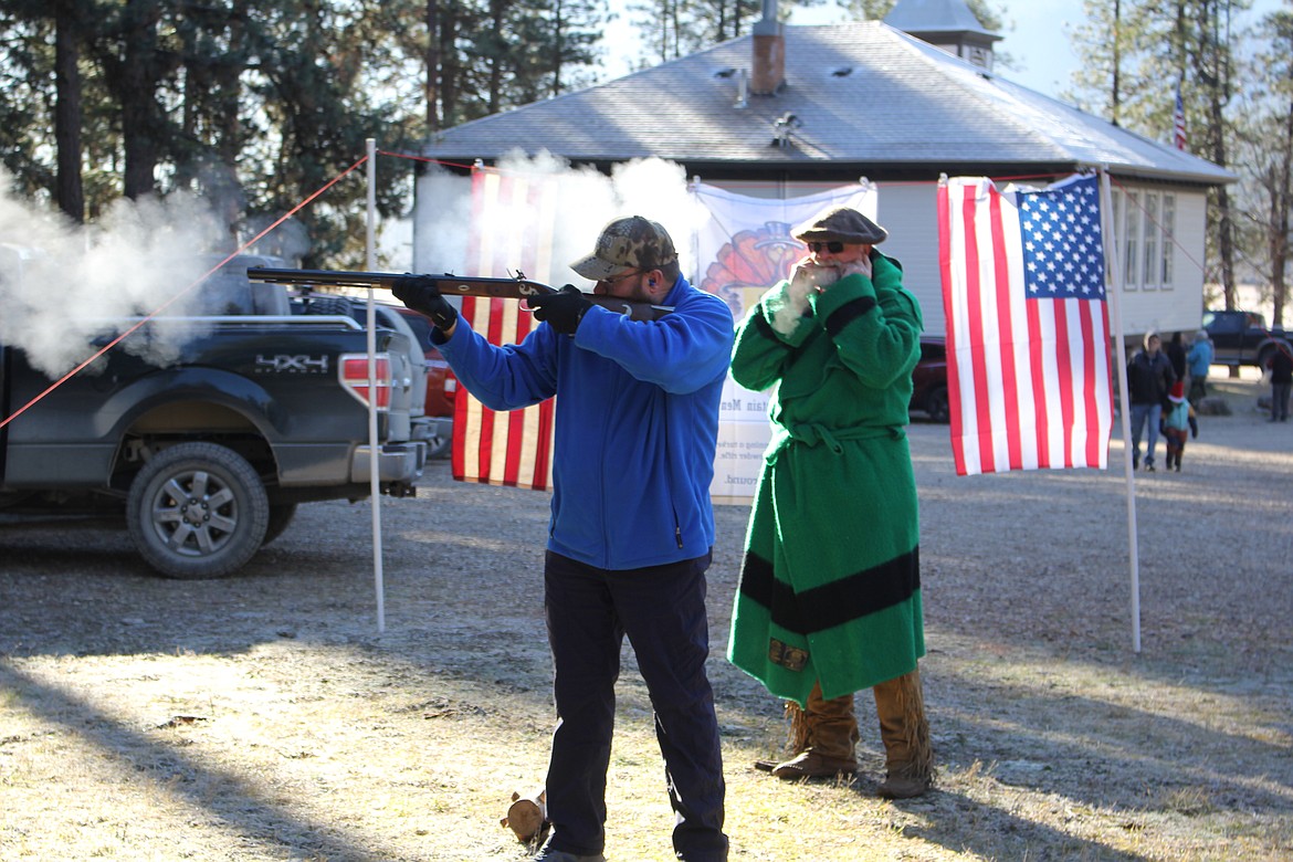 Mike Tomell with the Sapphire Mountain Men (green robe) along with his wife, Debbie, and member Bob Brugh coached and were safety instructors at the 9-Mile Community Center Turkey Shoot on Saturday. Turkeys and Cornish game hens were prizes for 1st and 2nd place in each volley of 8 shooters. The Saphire Mountain Men are the host organizers of the Wildhorse Rendezvous in Cyr, Montana every Memorial Day weekend.