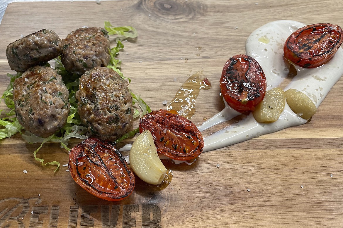 Believer Meats Research and Development Chef Andres Voloschin diplays a dish made from the company's cultivated lamb product at a test kitchen in Rehovot, Israel on Feb. 13, 2023. Believer is one of a growing number of companies making cultivated meat, which can be produced without raising and killing animals. (AP Photo/Laura Ungar)