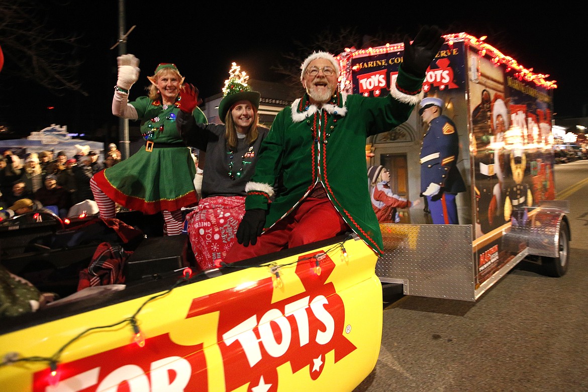 Tina Batha, left, Shannon Coder, and Floyd Duggar ride in the Toys for Tots vehicle in the Lighting Ceremony Parade on Friday in Coeur d'Alene.