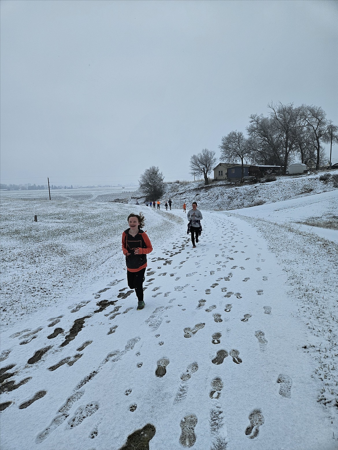 A pair of young runners set the pace during the snow-covered 2023 Turkey Trot fun run Thursday at Plains High School.  PHS student Ahsley Ferlan won the event over the 1.3 mile course, with Kalen Chenowith placing second. (Gena Ferlan photo)