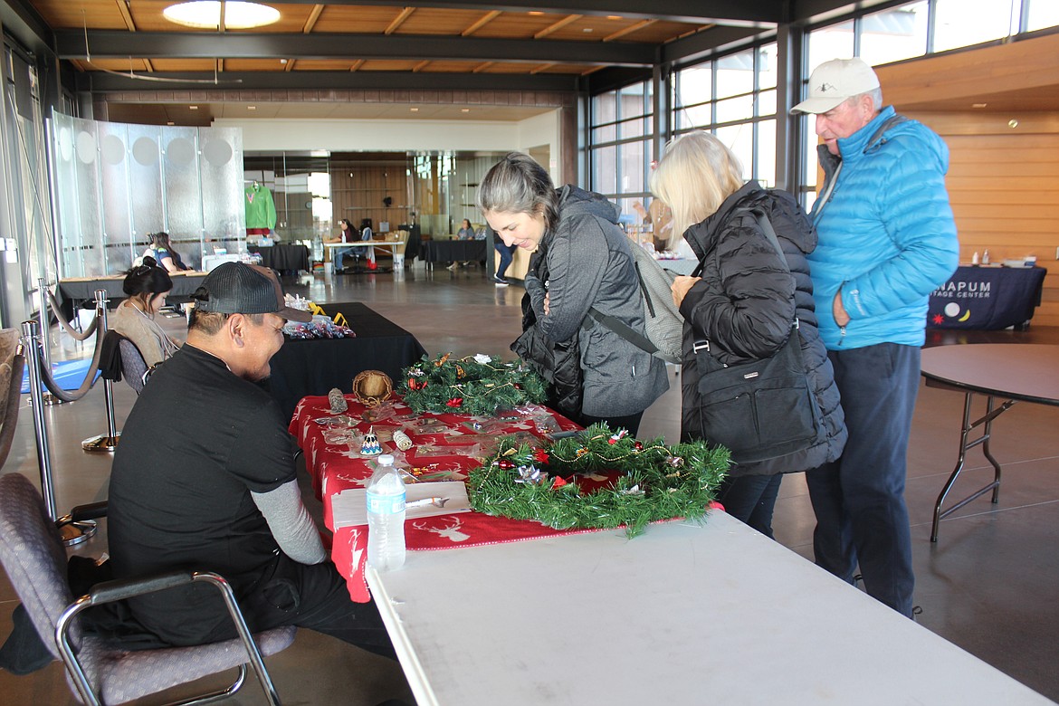 Alex Buck, left, talks with interested shoppers at the Wanapum bazaar.