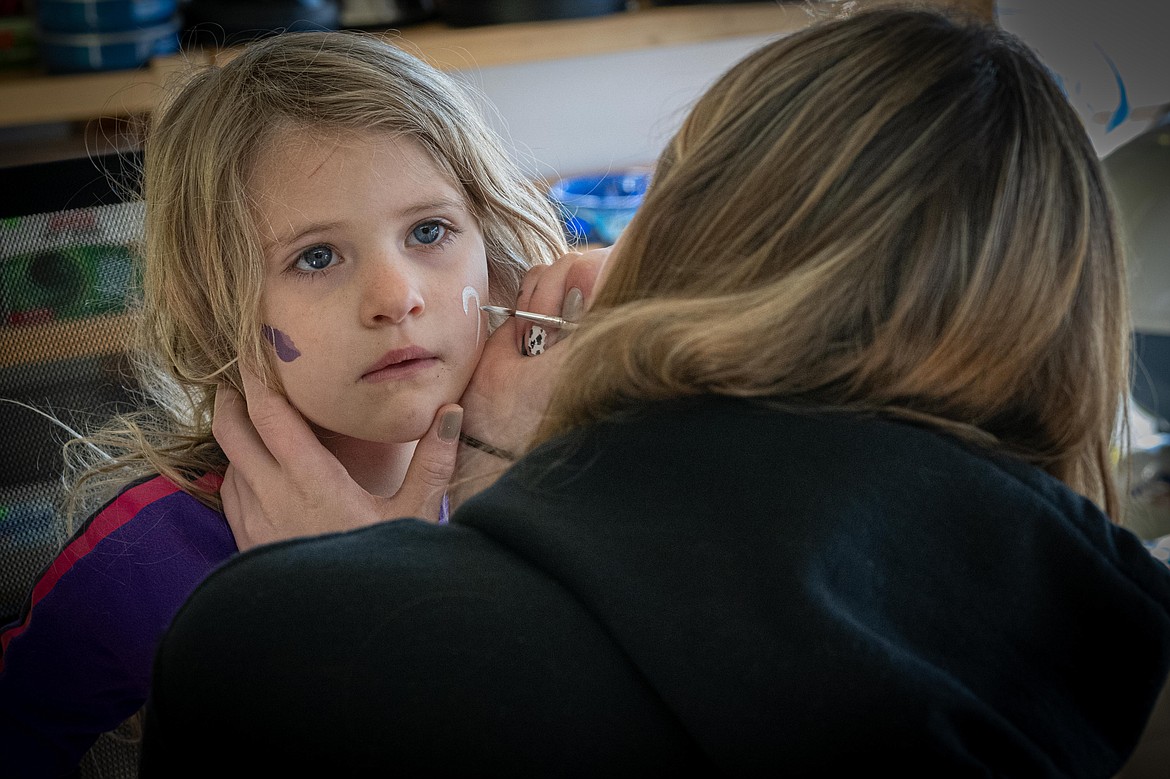 Josie Frankhause, 5, has her face painted by Plains High School sophomore Macy Malmend at the 406 Outlet and Coleens Country Store. (Tracy Scott/Valley Press)