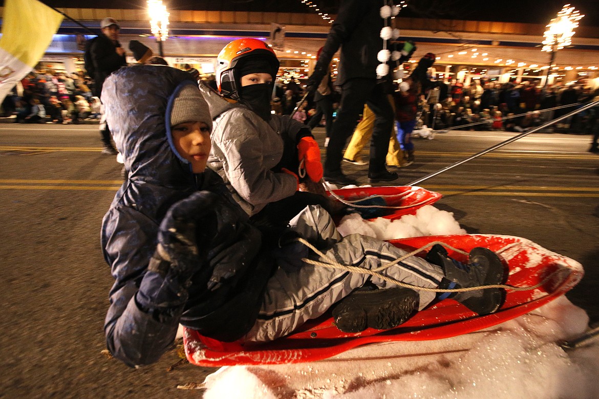 Two boys get a sled ride in the parade.