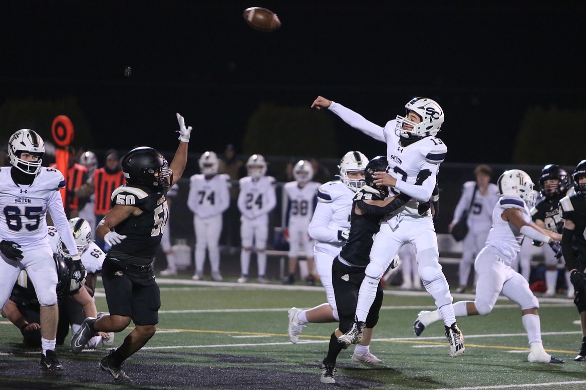 Royal seniors Jared Lee (33) and Juan Morales (50) get past the Seton Catholic offensive line a pressure quarterback Kolten Gesser (13).