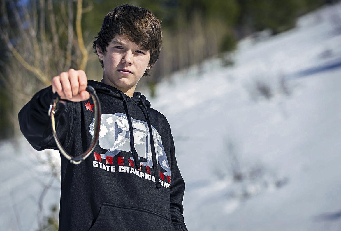 In this March 17, 2017, file photo, Canyon Mansfield holds the collar of his dog Kasey, who was killed the day before by a cyanide-ejecting device placed on public land by federal workers to kill coyotes near his home in Pocatello, Idaho. Citing public safety concerns, the Bureau of Land Management is ending the use of spring-loaded booby traps planted on public lands that eject cyanide powder when triggered to kill coyotes and other livestock predators, a practice wildlife advocates and others have been trying to outlaw for decades. (Jordon Beesley/The Idaho State Journal via AP, File)