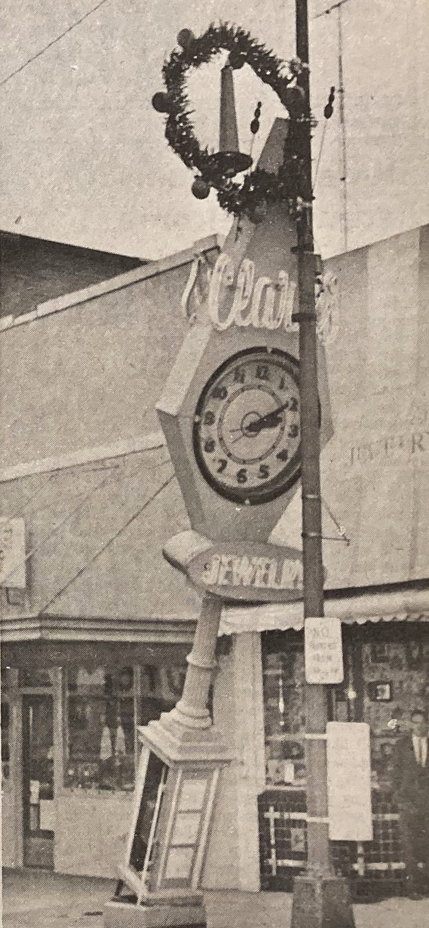 A light pole saves Clark’s Diamond Jewelers clock from destruction.