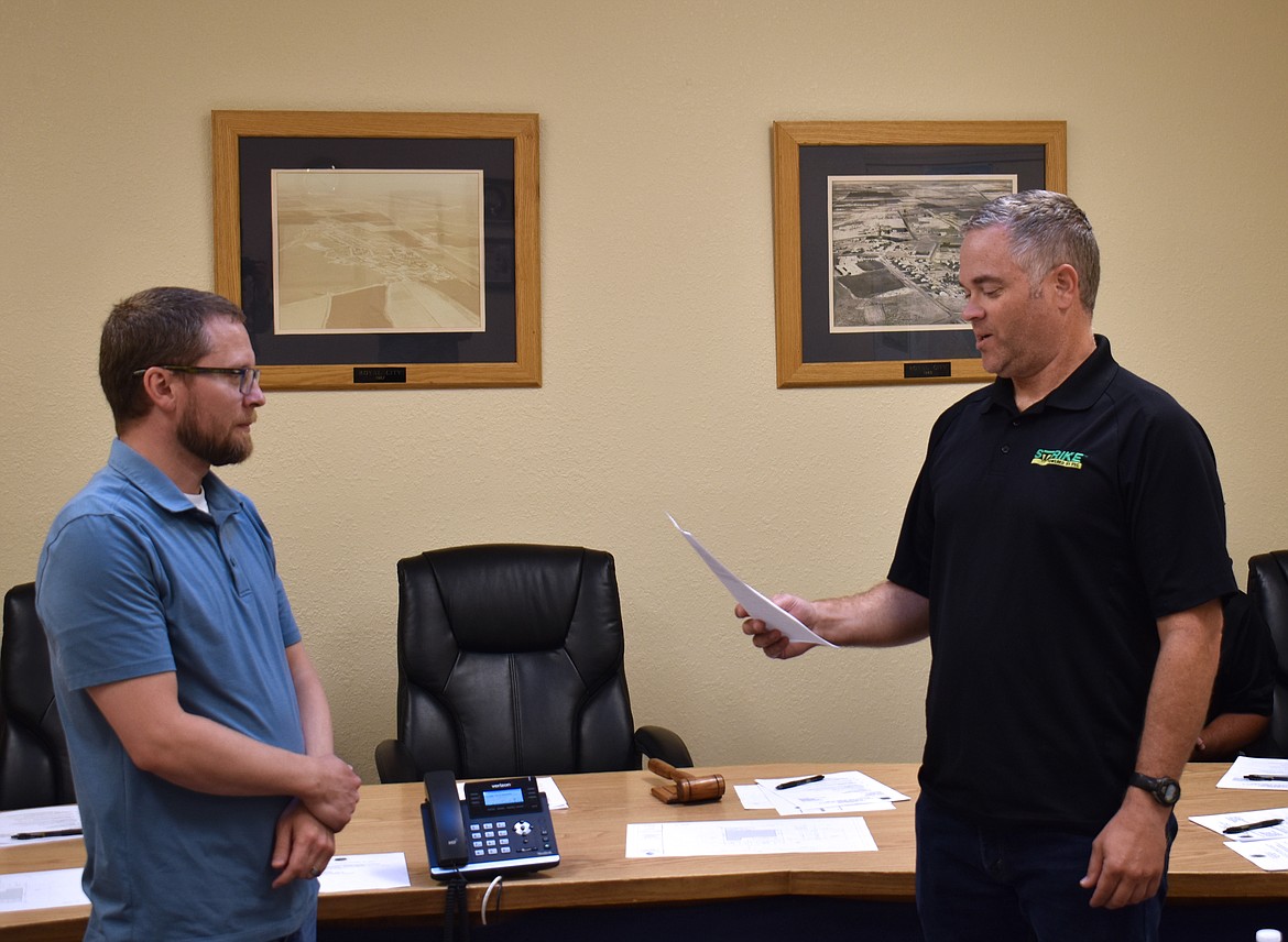 Ryan Piercy, right, is sworn in to a seat on the Royal City City Council by then-Finance Director Shilo Christensen, left. Piercy defeated challenger Stanton Fanning by two votes, but the race may qualify for a mandatory recount.