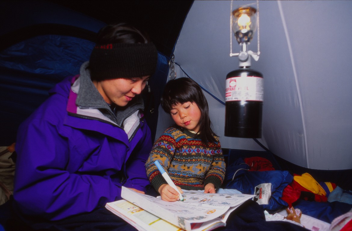 Harada's daughter and his wife Kumi hangout in their tent, braving the cold while Harada shot wildlife photography in Many Glacier. (courtesy of Sumio Harada)