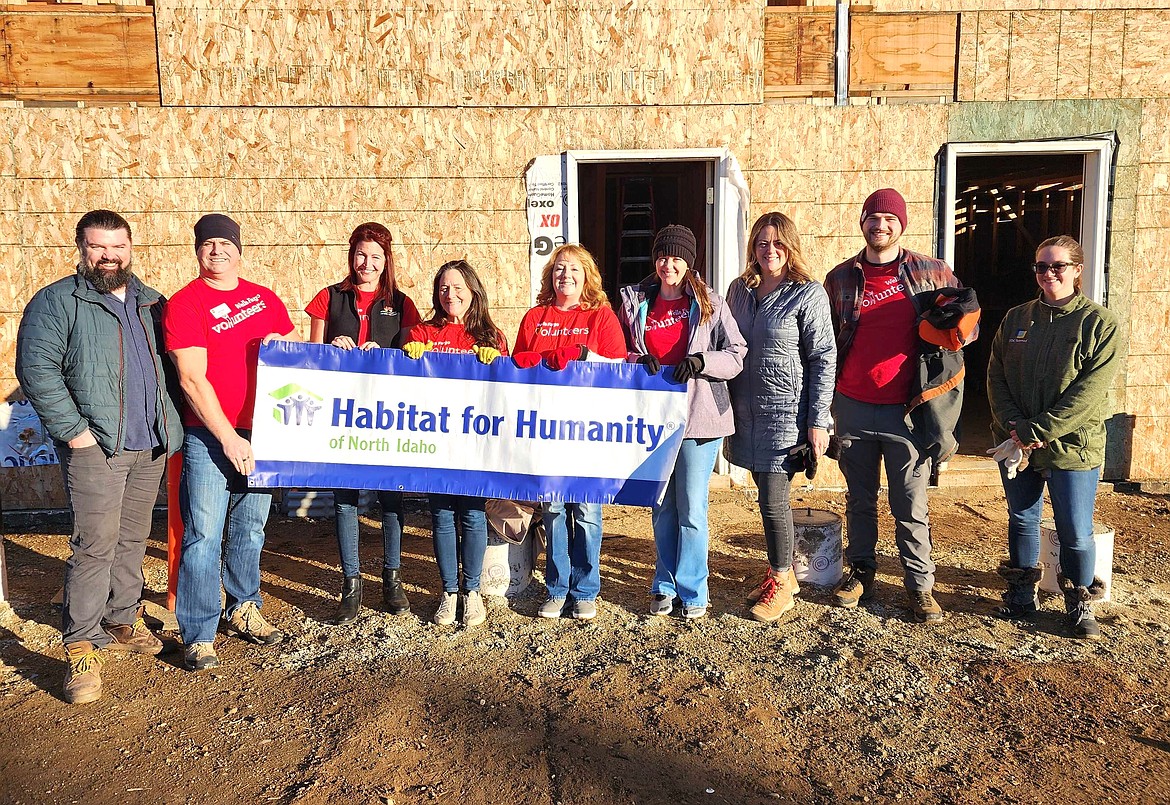 James Casper, executive director of Habitat for Humanity of North Idaho, left, joins volunteers Jason Noble, Christi Garcia, Monique Worley, Carolyn Jorgensen, Kim Cummings, Allison Bishop and Trevor Pew from Wells Fargo on Second Street in Coeur d'Alene where 21 condominiums are being constructed for low-income families.