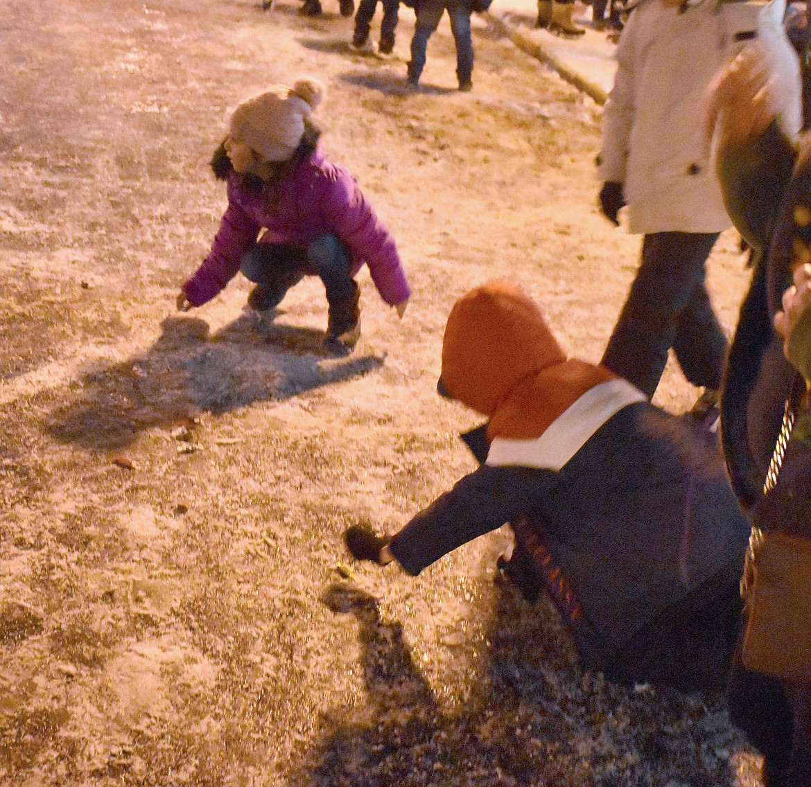 Children dash through the snow after candy thrown in the Moses Lake Ag Appreciation Parade Friday.