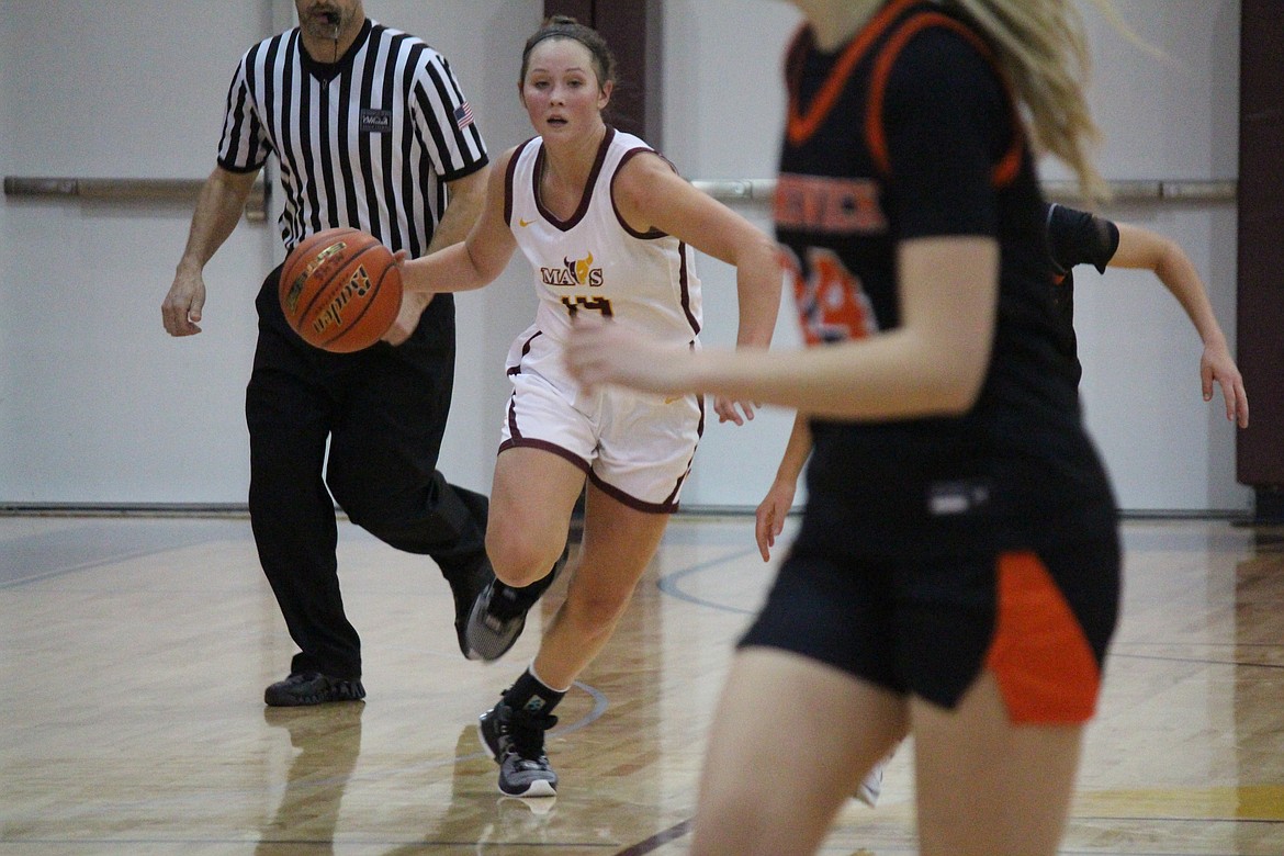 Lexi Cox (14) pushes the ball up the floor in the season opener for Moses Lake Nov. 30.