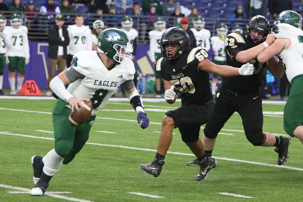 Royal senior Juan Morales (50) chases after Lakeside (Nine Mile Falls) quarterback Calvin Mikkelsen in the first half of Friday’s 1A State Football championship game.