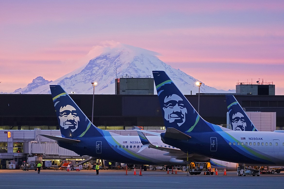 Alaska Airlines planes are shown parked at gates with Mount Rainier in the background at sunrise, March 1, 2021, at Seattle-Tacoma International Airport in Seattle. Alaska Air Group said Sunday, Dec. 3, 2023, that it agreed to buy Hawaiian Airlines in a $1 billion deal. (AP Photo/Ted S. Warren, File)