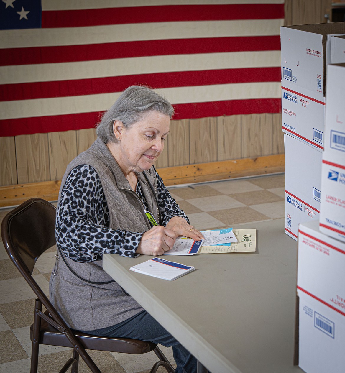 Janet Brandon addresses each of the packages that will be sent to active duty service members from Sanders County. (Tracy Scott/Valley Press)