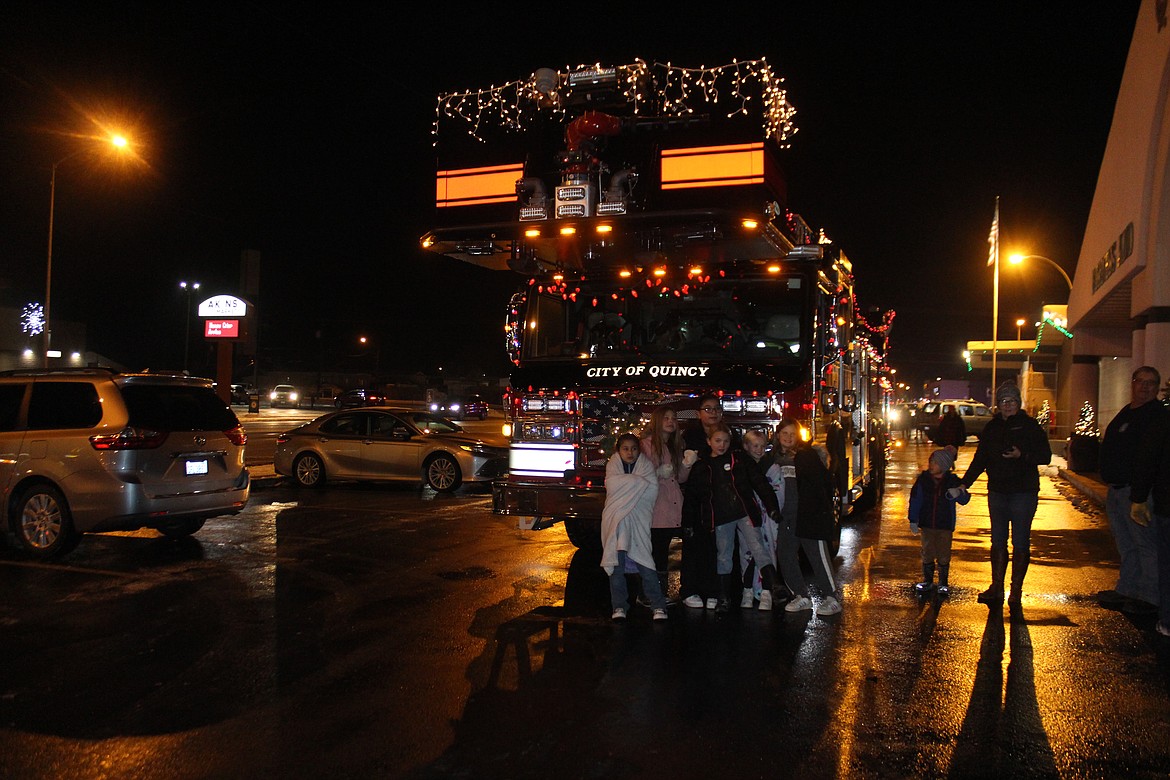 Children stop for a picture with the ladder truck from Grant County Fire District 3, all decked out in lights.