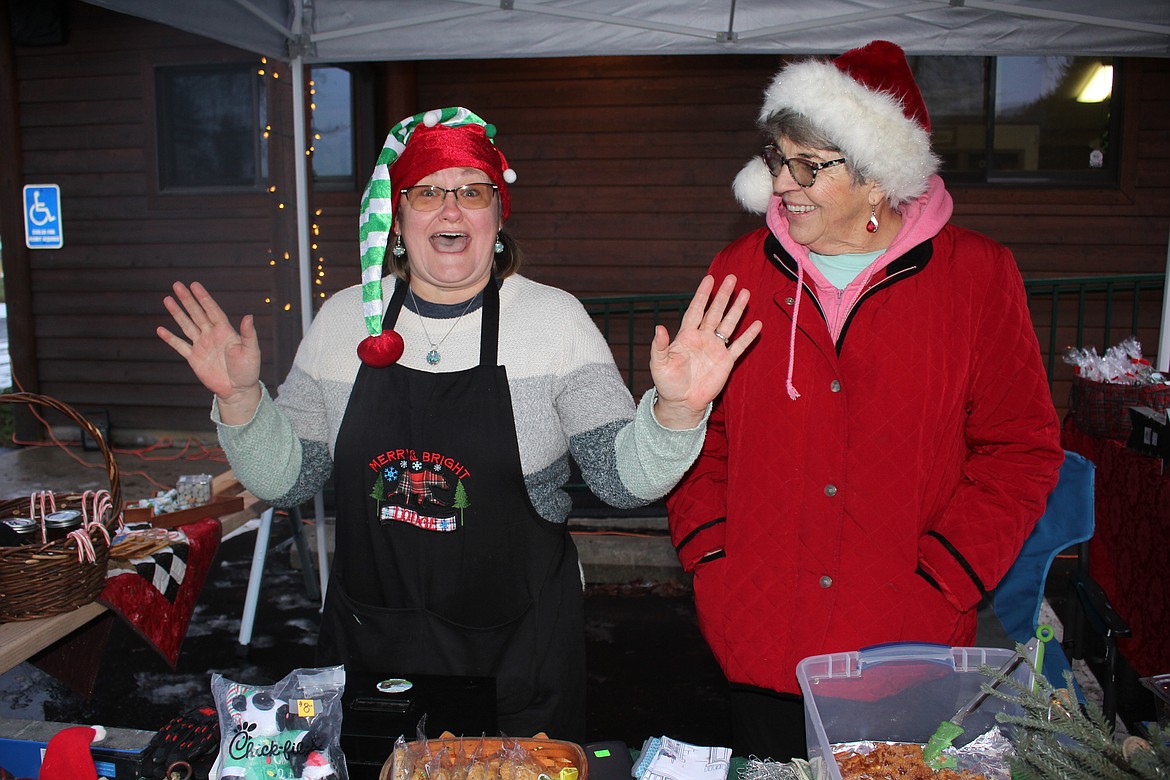 Naomi Mesenbrink, owner of The Phun-E Farm in DeBorgia, might have had the most exuberant merchant Saturday at the Christmas Tree Lighting in Superior. Volunteer Dana Samson realizes that she’s probably going to have to break down their booth by herself. (Monte Turner/Mineral Independent)