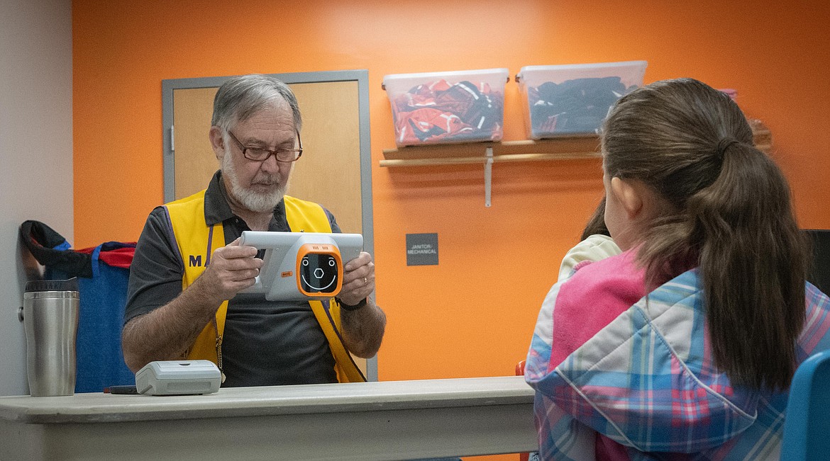 Lions Club volunteer vision tester Marvin Tanner with a Plains student. (Tracy Scott/Valley Press)