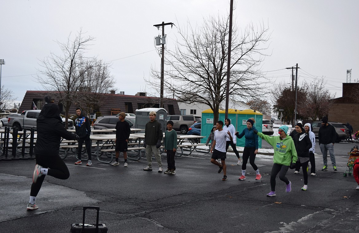 Runners warm up to dance music with a Feel Good Fitness instructor prior to the race.