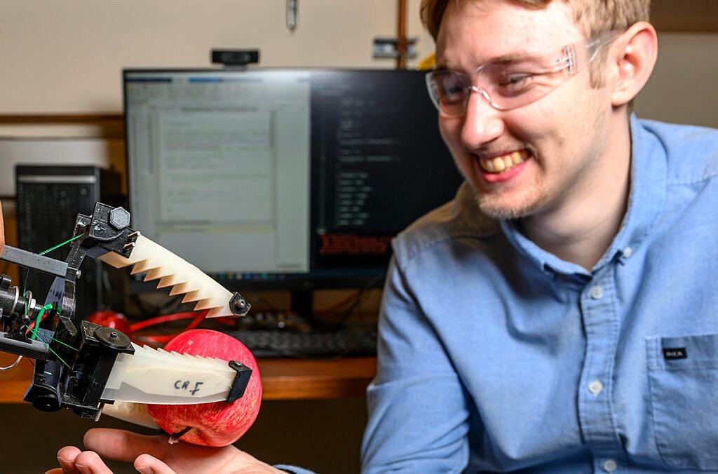 WSU doctoral student Justin Allen demonstrates a picker attachment being developed to advance soft robot technologies.