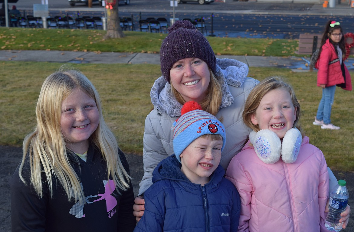 Othello native Bonnie Giles stands behind her children Ally, left, Teddy and Samantha Saturday afternoon during Othello’s Christmas celebration. Giles said her family attends every year.