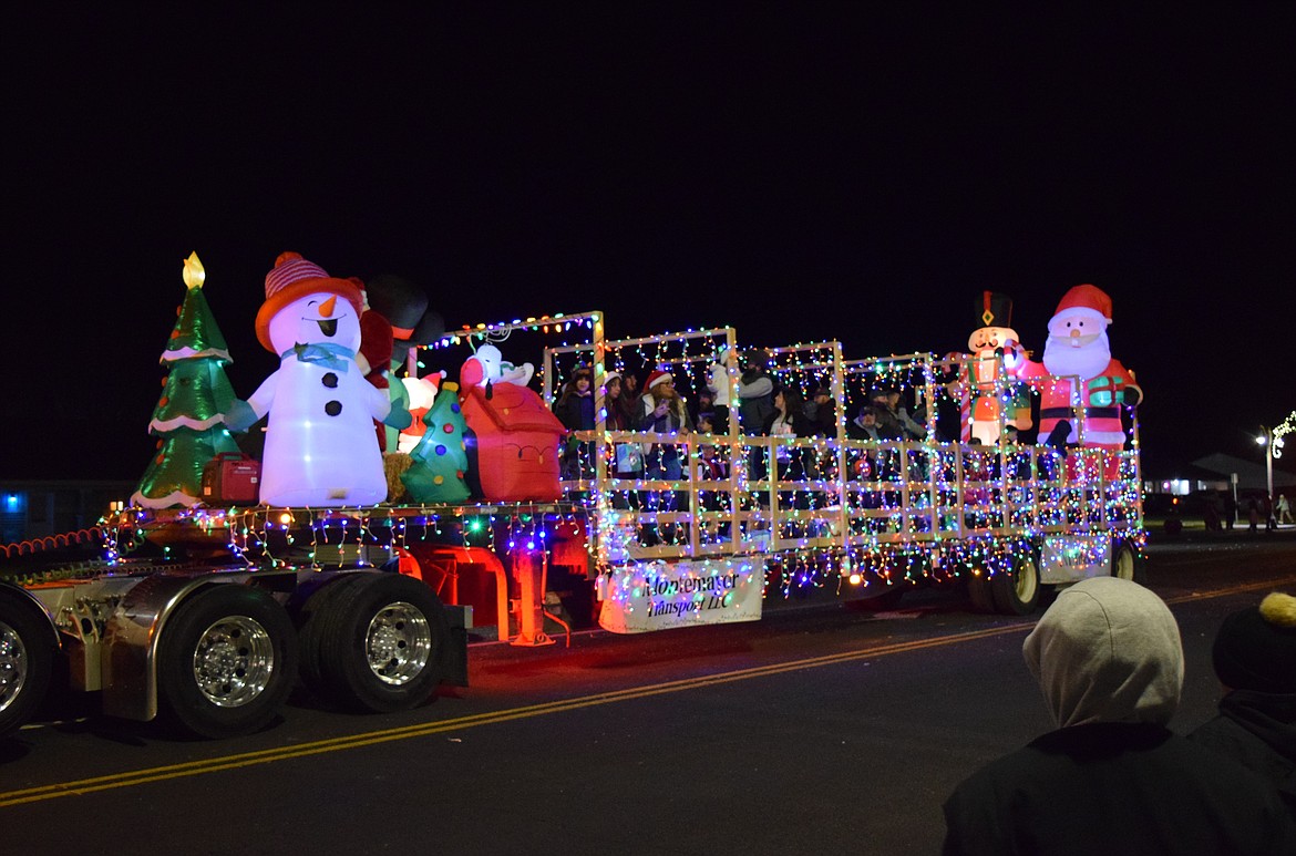 A truck trailer wrapped in Christmas lights with holiday-themed inflatables goes down Main Street during the Christmas Miracle on Main Street parade Saturday evening.