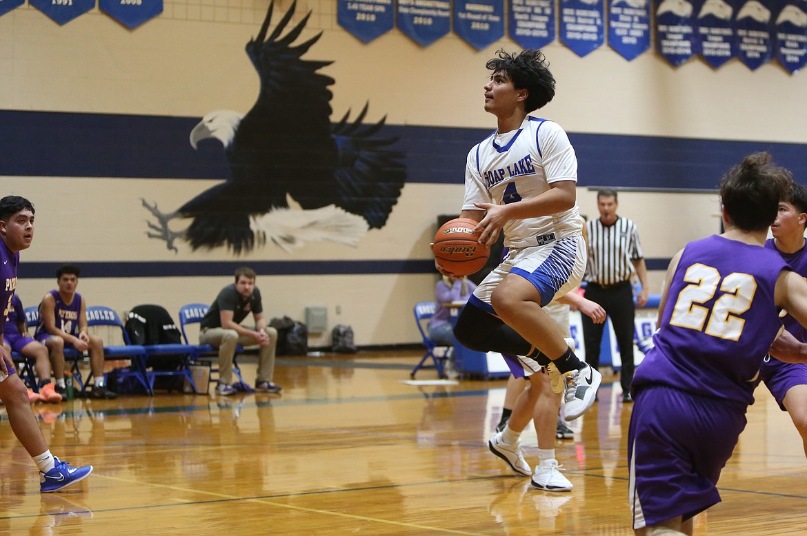 Soap Lake junior Jairo Lopez, in white, keeps his eyes on the rim while jumping in the air before making a basket against Pateros.