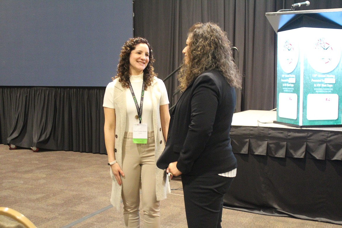 Jacqui Gordon-Nuñez, left, talks with a Washington Department of Agriculture attendee at the horticultural association meeting.