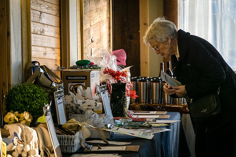 An attendee at the Gathered in Gratitude dinner looks over the silent auction items. The November dinner raised more than $35,000 for McKay Healthcare and Rehabilitation.