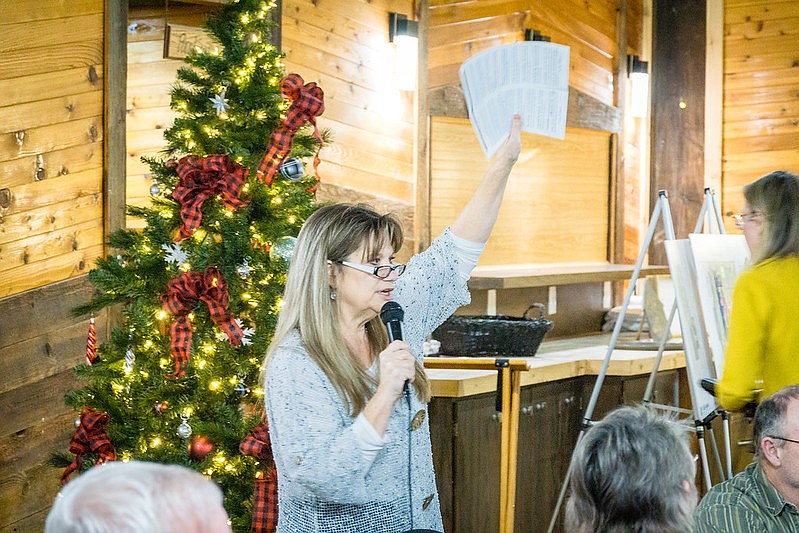 McKay Healthcare and Rehabilitation commissioner Cindi Rang looks over the bidders during the Gathered in Gratitude dinner.