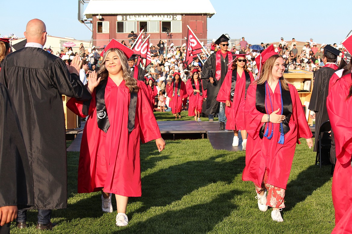 Othello students walk down an aisle during Othello High School’s 2023 graduation ceremony in June.