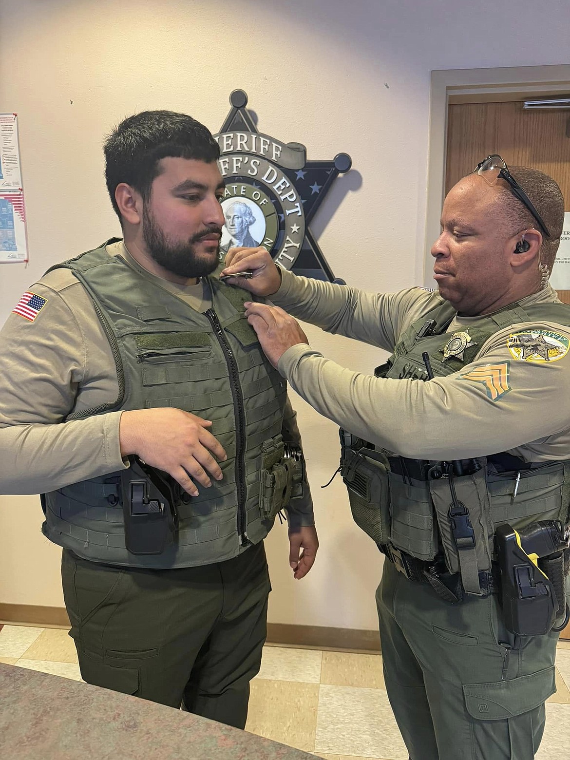 Adams County Sheriff’s Office Jail Commander Sgt. Darryl Barnes pins a badge on the Sheriff’s Office’s newest corrections deputy, Gustavo Vasquez, who was sworn in Wednesday.