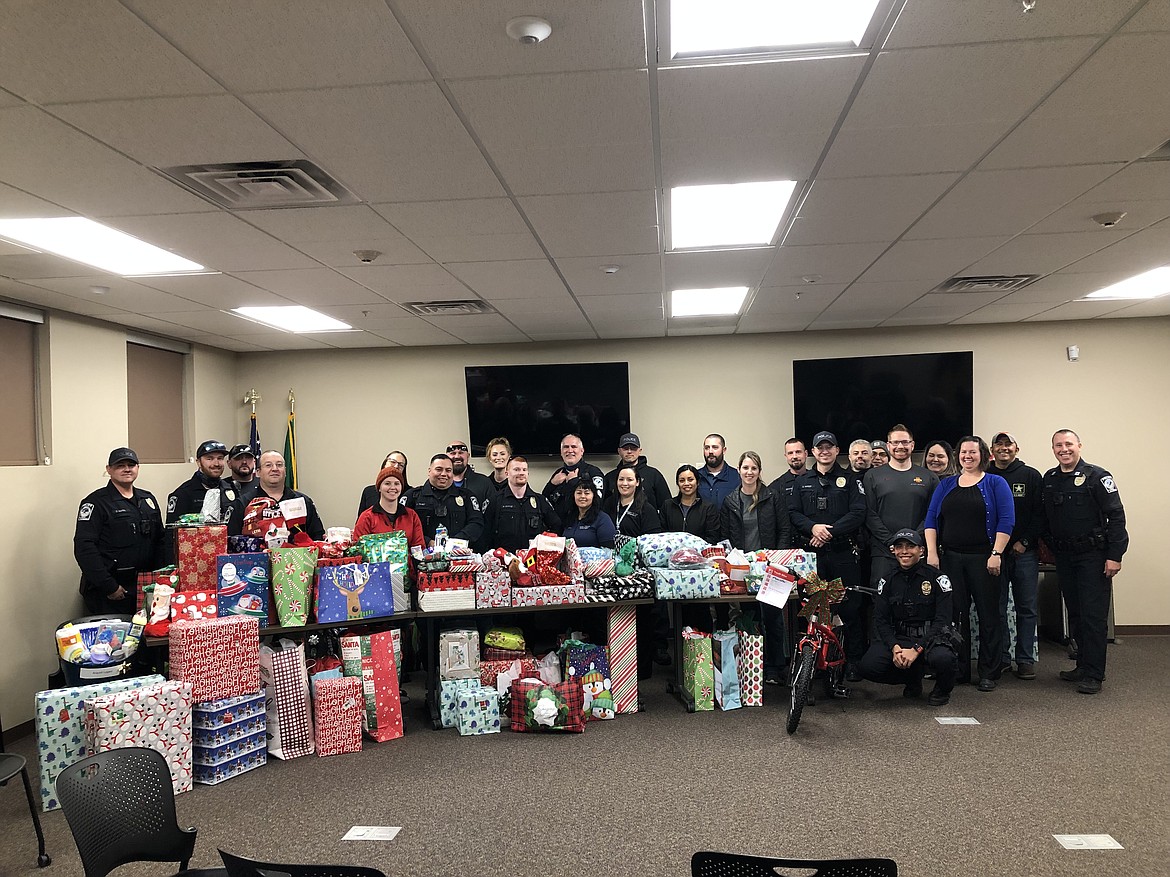 Quincy Police Department officers, their families and volunteers pose with a pile of presents for children and their families from the 2022 Shop With a Cop. The department is sponsoring a fundraising raffle for 2023 through Dec. 15.