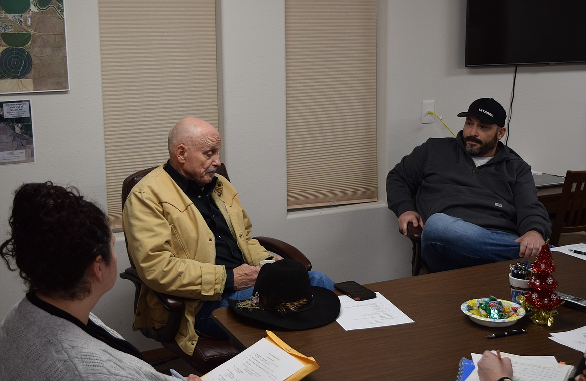 State Representative Tom Dent, R-Moses Lake, yellow jacket, sits in the Port of Warden’s offices Wednesday evening discussing the future of Warden Airport during the regular port meeting.