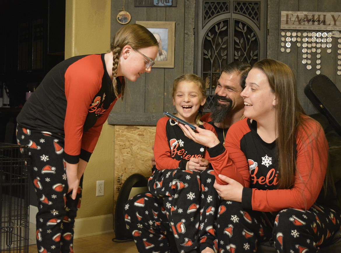 Ella Weaver and Elissa Weaver huddle with Tausha Winn and Matthew Hunter as they received a call from Santa Claus.