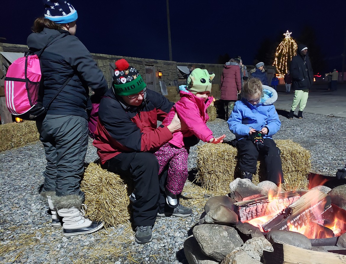 From left, Laurie, Jeff, Peyton and Maddie Higgins warm up by a fire before a reenactment of Jesus' birth at Stateline Speedway on Saturday.