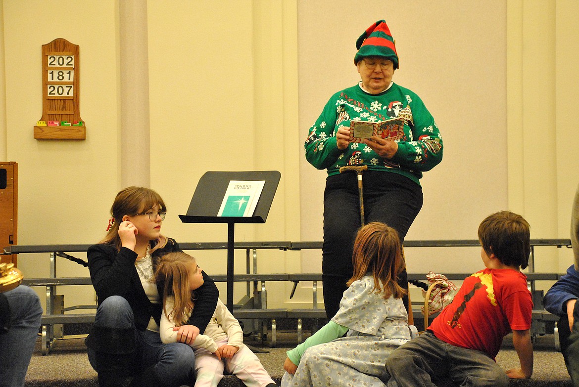 One of Santa's helpers, Mary Murphy-Kellis invited the children in the crowd to come down and sit at her feet as she read the story of the Candy Cane and how the J is for Jesus. She then handed out handmade bead candy cane ornaments for the kids to bring home. (Mineral Independent/Amy Quinlivan)