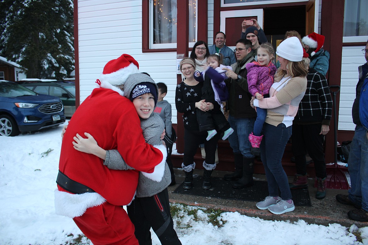 “Santa is a hugger,” the jolly old elf said as he was welcomed by the children on the steps of the Old DeBorgia School Sunday.