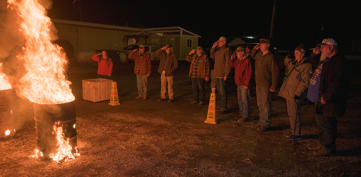 Veterans salute in respect after retiring 104 flags. (Tracy Scott/Valley Press)