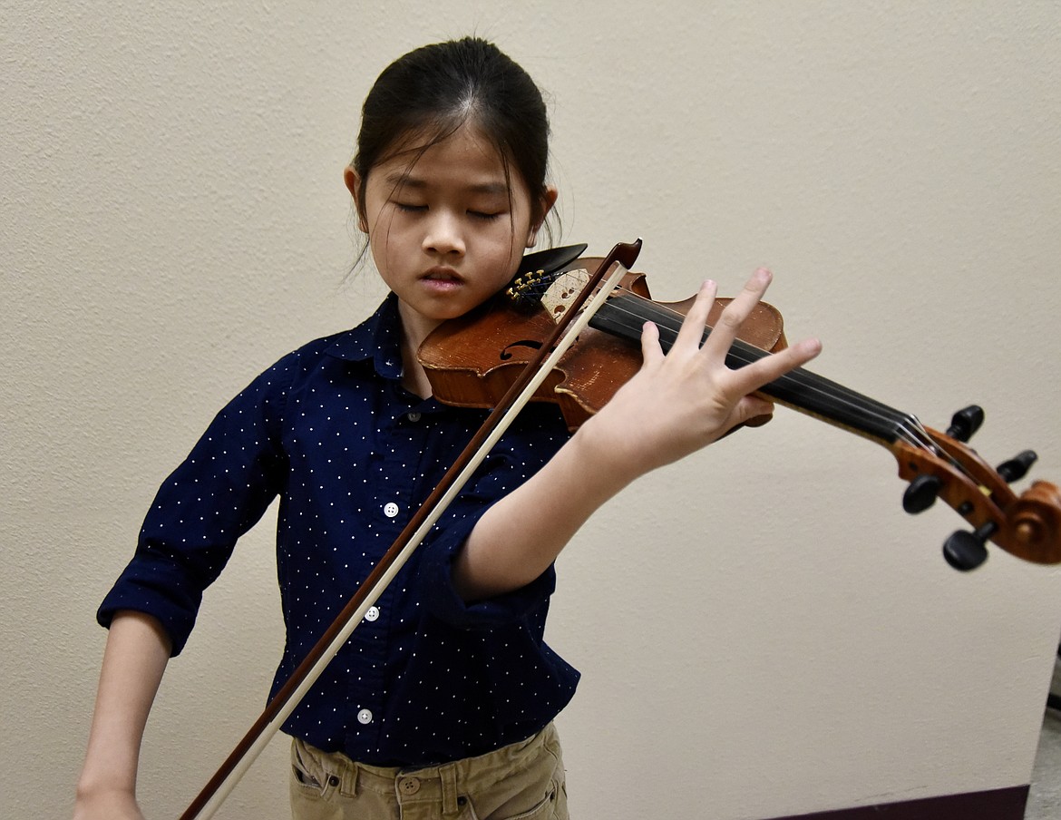 ZIAO CHEN, 9, practices playing the violin, his favorite instrument, at Flathead Valley Community College Nov. 6, 2023. (Hilary Matheson/Daily Inter Lake)