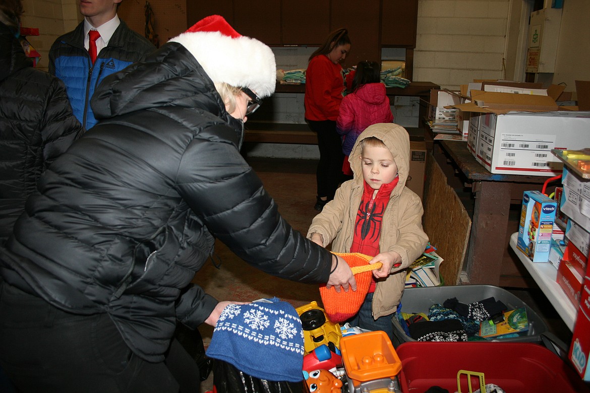 Jennifer Baginski, right and her nephew Eli Baginski look for just the right hat while bagging toys for the Othello Christmas Basket project in 2021. Donations for 2023 are being accepted through Thursday.