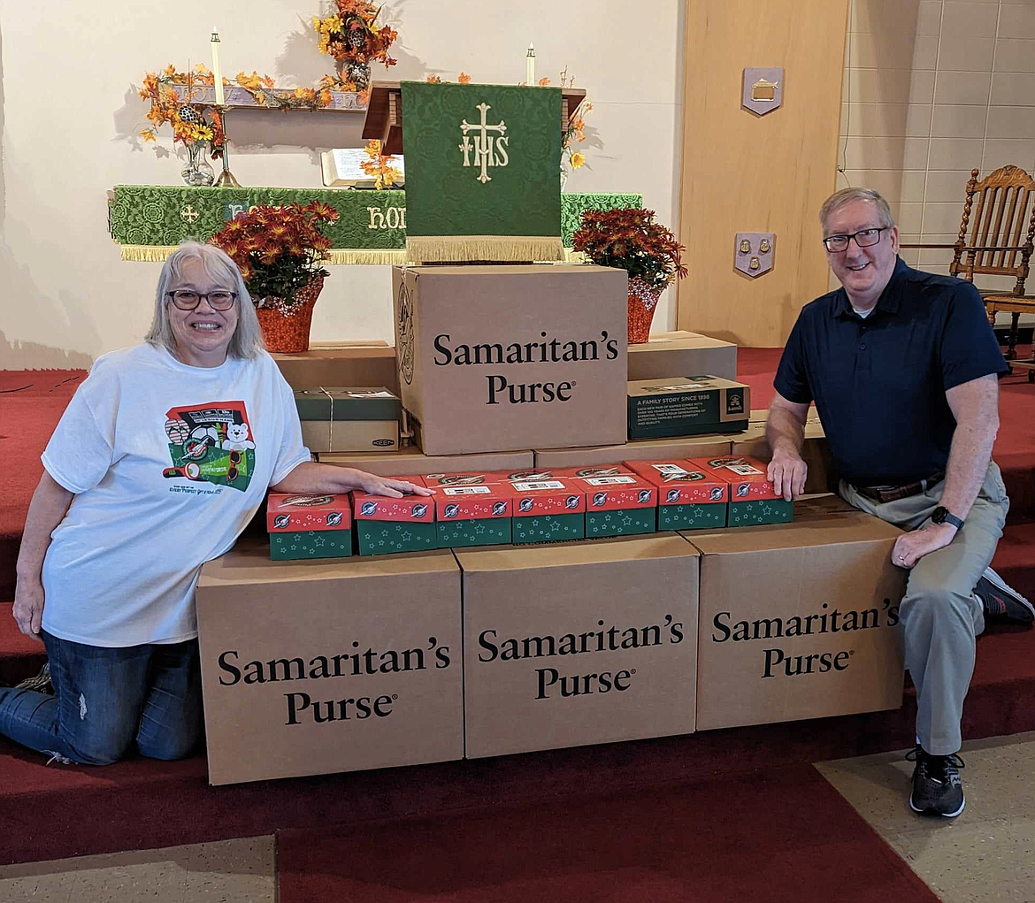 Linda and David Langer pose with cartons of shoeboxes with presents ready to be shipped and distributed during Operation Christmas Child in the Silver Valley.
