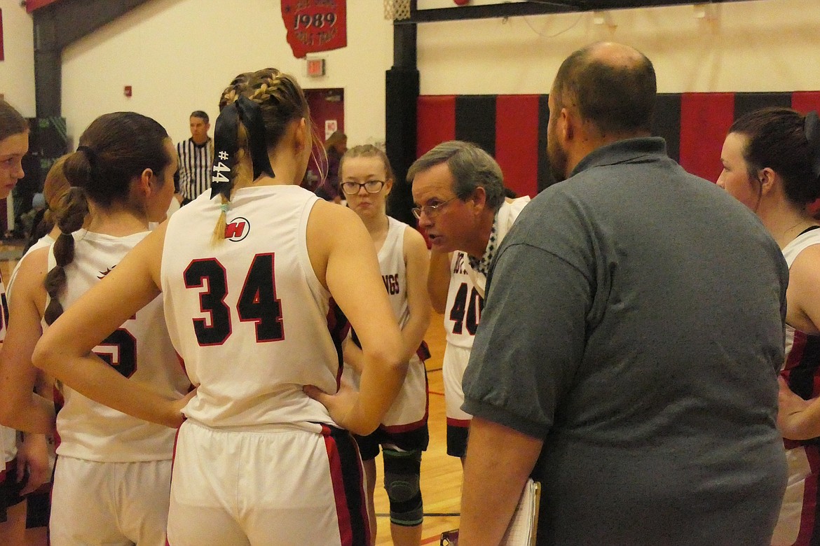 Hot Springs head coach Richard Jackson (glasses) goes over strategy with the Lady Heat during a timeout of their game versus Arlee Saturday evening in Hot Springs. (Chuck Bandel/VP-MI)