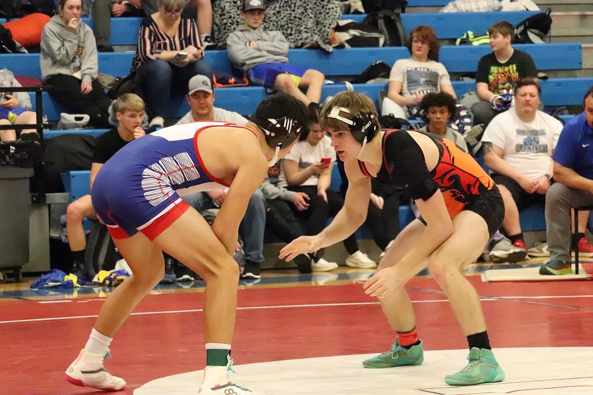 Plains/Hot Springs 152-pounder John Waterbury (orange and black) prepares for a takedown move on this way to the 152 individual title at the Bob Kinney last weekend in Superior. (Photo by Kami Milender)