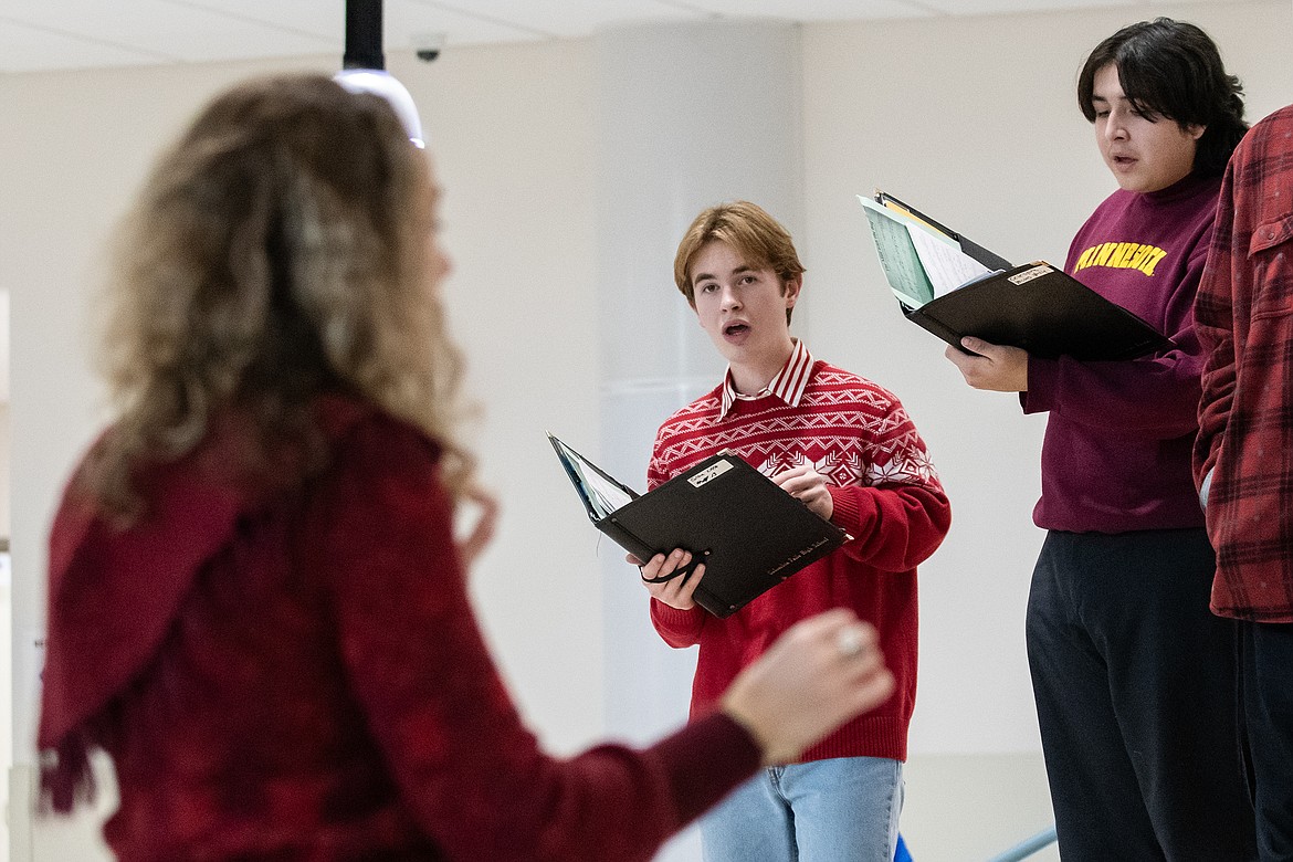 Columbia Falls High School choir director Emily Hackethorn leads Colton Little and Celestine Young in Christmas carols for the students at Glacier Gateway Elementary on Wednesday, Dec. 6. (Avery Howe photo)